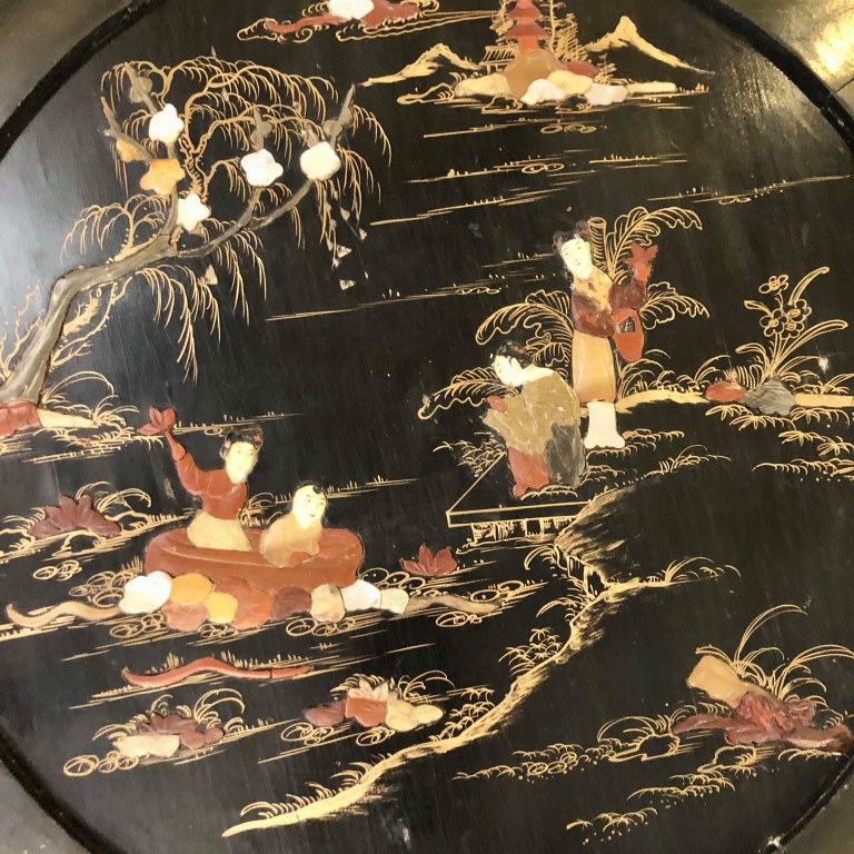 A round antique Chinese black lacquer foldable low coffee table with inlaid pearl and stone pictures. Size: 0.51m (height) x 0.66m (diameter width)  Price: R6,000.00